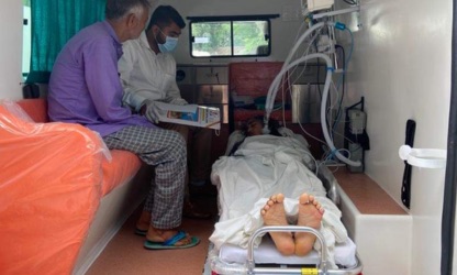 Paramedic caring for a patient on ventilator support inside the ambulance